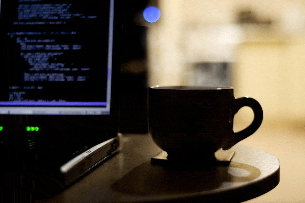 Animated GIF showing steam rising from coffee cup next to laptop